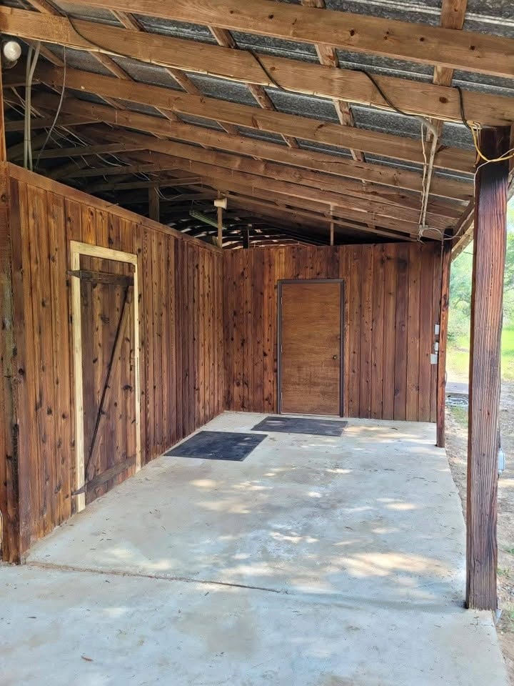 Covered exterior structure showing roof framing above a finished doorway