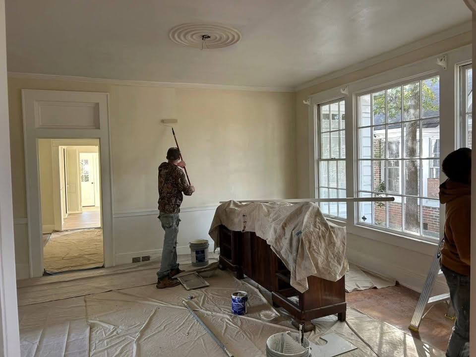Interior room being painted with floors and furnishings protected
