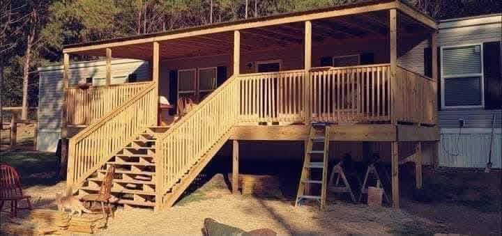 Covered wooden deck and porch with stairs and railings